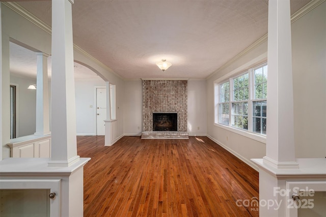 8080 Monbo Rd, Catawba, NC 28609 - unfurnished living room featuring ornamental molding, a fireplace, ornate columns, and wood finished floors