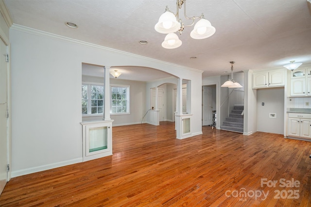 8080 Monbo Rd, Catawba, NC 28609 - unfurnished living room featuring stairs, crown molding, arched walkways, and light wood-style floors