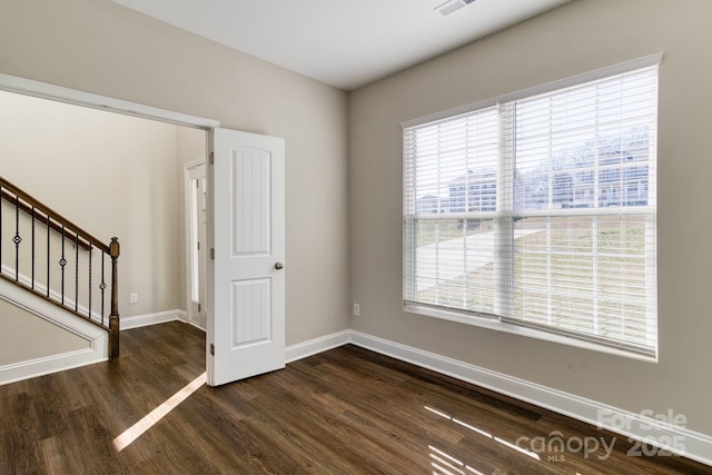 interior space with stairs, wood finished floors, visible vents, and baseboards