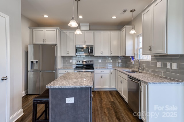 kitchen featuring appliances with stainless steel finishes, dark wood finished floors, visible vents, and a sink