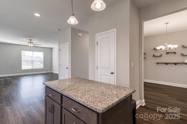 kitchen featuring dark brown cabinetry, dark wood-style floors, baseboards, and pendant lighting