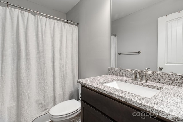 full bathroom with curtained shower, vanity, and toilet