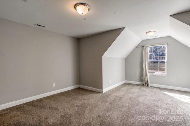 bonus room with baseboards, visible vents, vaulted ceiling, and carpet flooring