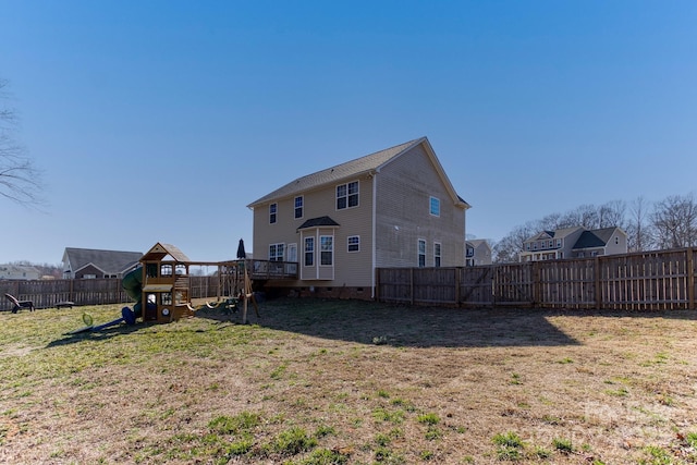 rear view of house with a yard, crawl space, a playground, and a fenced backyard