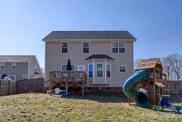 back of property with a playground, a yard, crawl space, a deck, and a fenced backyard