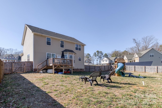 rear view of house featuring a playground, a lawn, crawl space, a fenced backyard, and a wooden deck