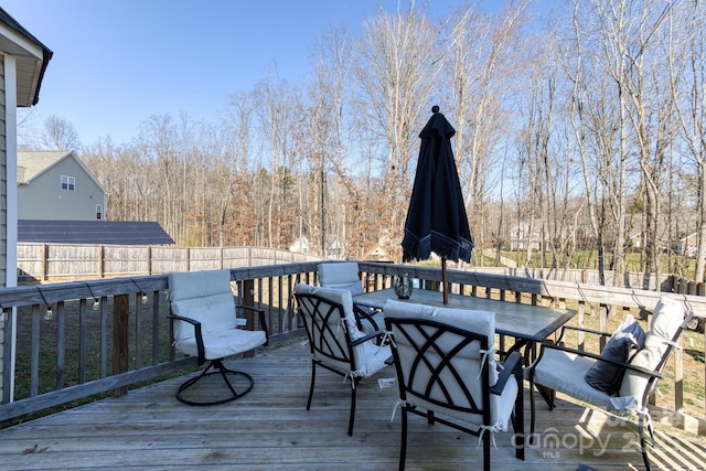 wooden terrace featuring outdoor dining area and fence