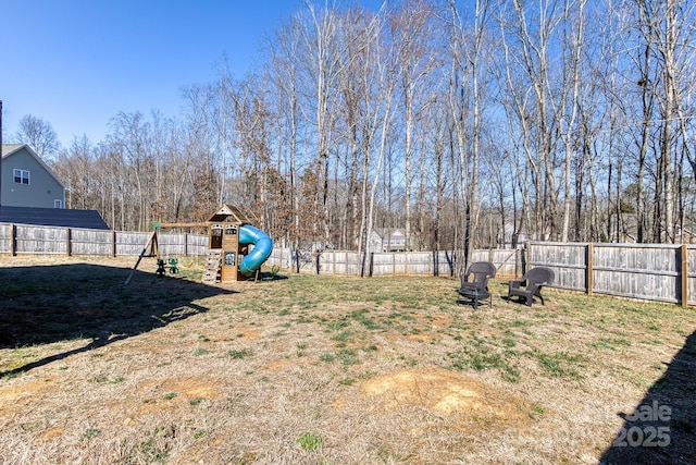 view of yard with a fenced backyard and a playground