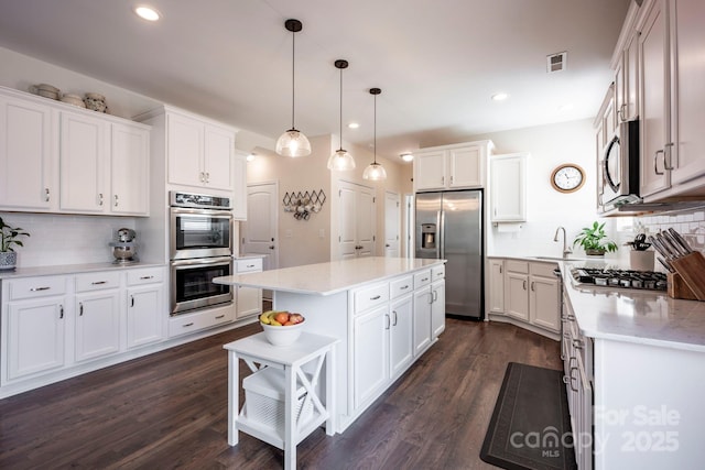 kitchen featuring appliances with stainless steel finishes, white cabinets, and dark wood finished floors