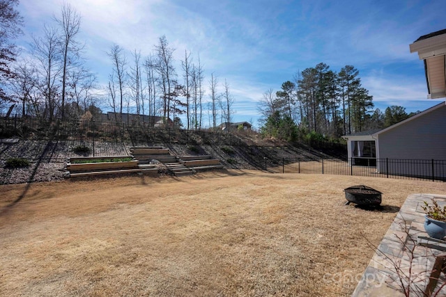 view of yard with a fire pit and fence