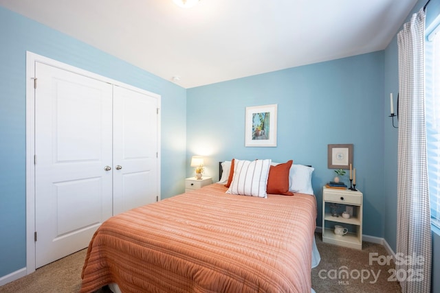 bedroom featuring carpet, baseboards, and a closet