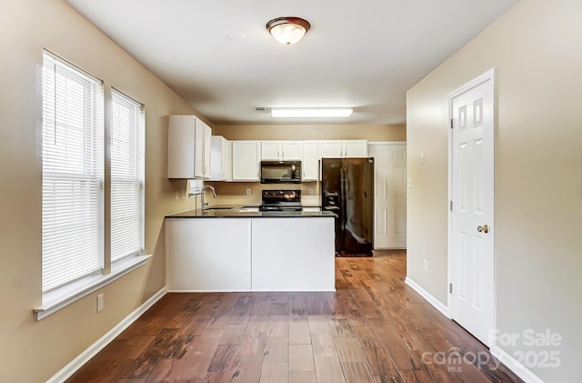 kitchen featuring a sink, white cabinets, black appliances, dark countertops, and dark wood finished floors