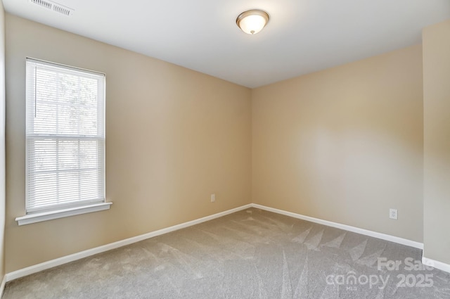 carpeted empty room featuring visible vents and baseboards