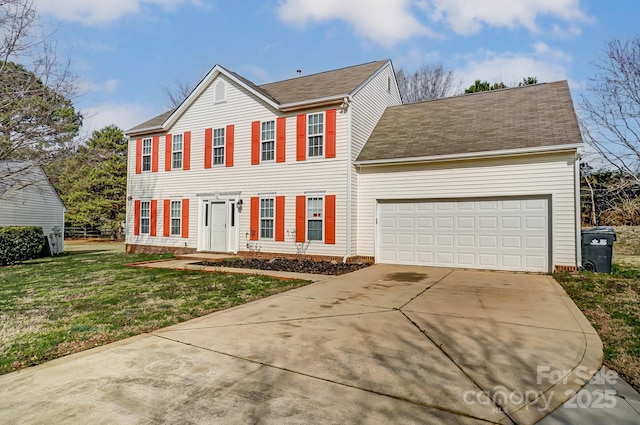 colonial inspired home with a front lawn, driveway, and an attached garage