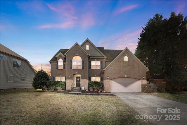 traditional home with a garage, a lawn, concrete driveway, and brick siding