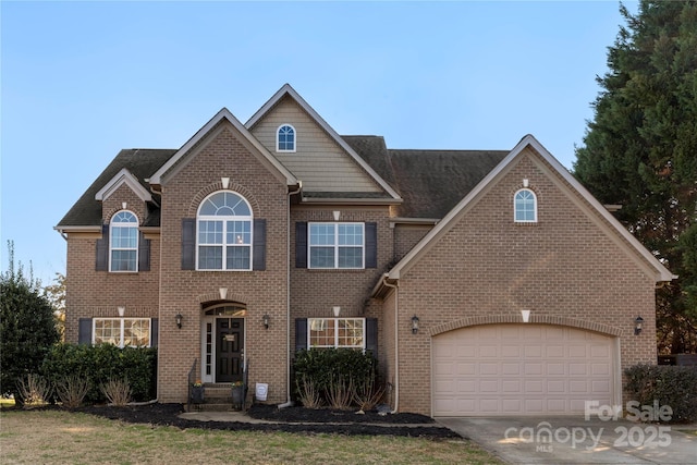 view of front of home with a garage, concrete driveway, and brick siding