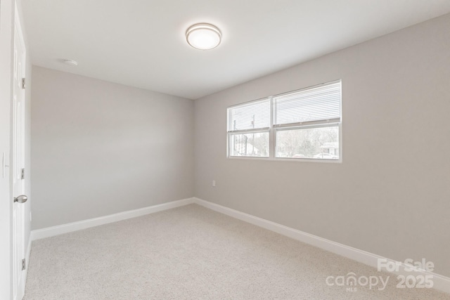 empty room featuring carpet flooring and baseboards