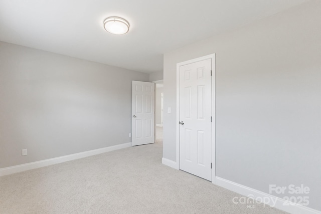 unfurnished bedroom with light carpet and baseboards