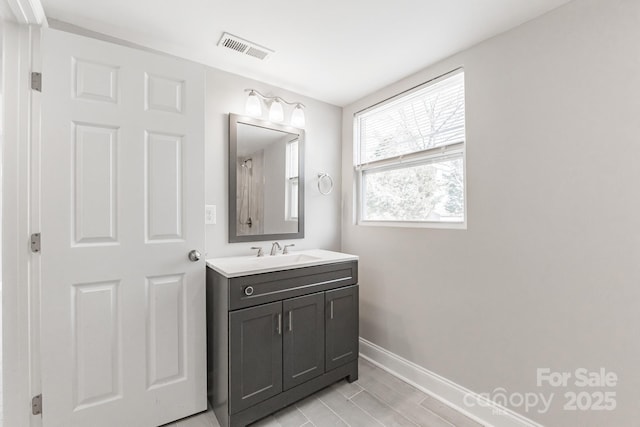 full bathroom featuring vanity, visible vents, and baseboards