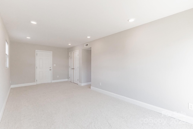 unfurnished room featuring recessed lighting, light colored carpet, and baseboards