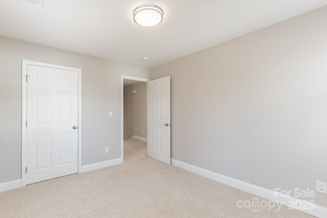 unfurnished bedroom featuring carpet floors and baseboards