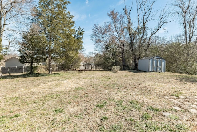 view of yard featuring a shed, an outdoor structure, and fence