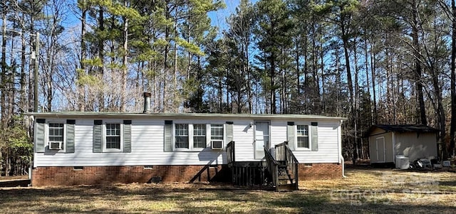 manufactured / mobile home featuring a storage unit, crawl space, and an outdoor structure