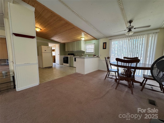 unfurnished dining area with light colored carpet, a ceiling fan, wood ceiling, vaulted ceiling, and visible vents