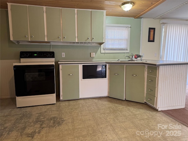 kitchen with light floors, a sink, range with electric cooktop, black microwave, and a peninsula