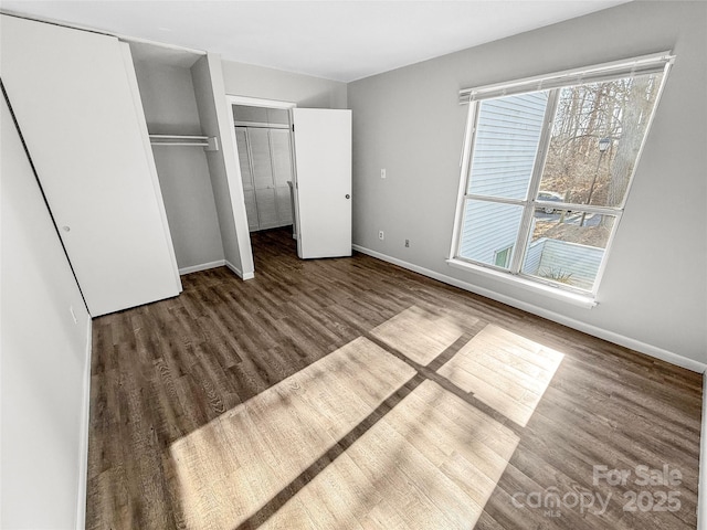 unfurnished bedroom featuring wood finished floors and baseboards