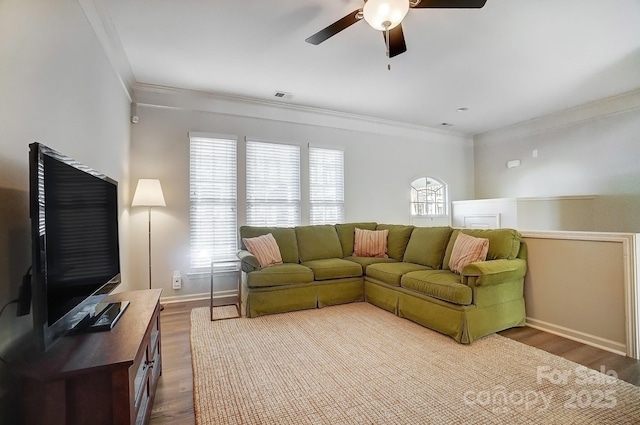 living room featuring plenty of natural light, crown molding, and wood finished floors