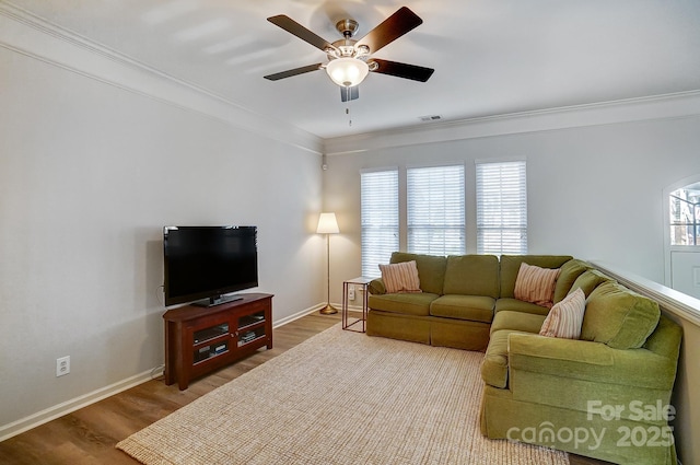 living room with a ceiling fan, wood finished floors, visible vents, and crown molding