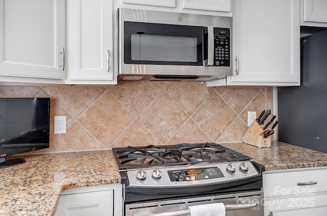 kitchen with white cabinets, light stone countertops, and stainless steel appliances