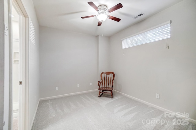 unfurnished room with a ceiling fan, light colored carpet, visible vents, and baseboards