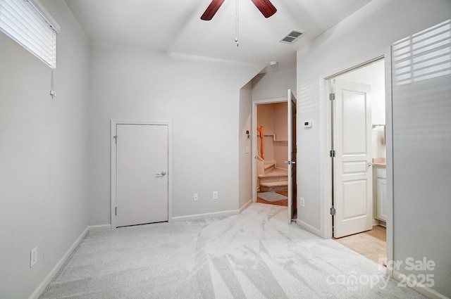 unfurnished bedroom with visible vents, ensuite bathroom, light carpet, ceiling fan, and baseboards