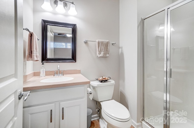 bathroom with toilet, a shower stall, and vanity