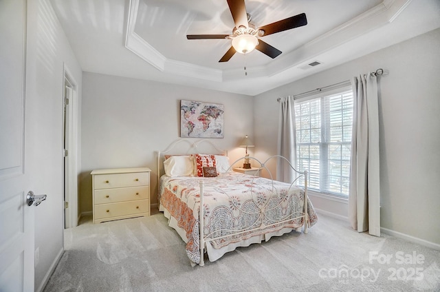 bedroom featuring a tray ceiling, visible vents, ornamental molding, light carpet, and baseboards