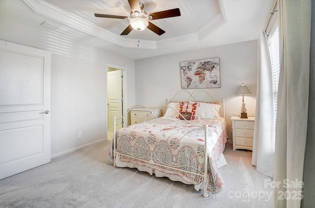 bedroom with a raised ceiling, light colored carpet, ornamental molding, ceiling fan, and baseboards