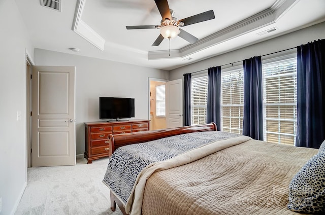 bedroom with light carpet, a raised ceiling, visible vents, and crown molding