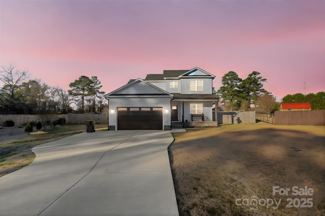 view of front of house with a garage, driveway, fence, and board and batten siding