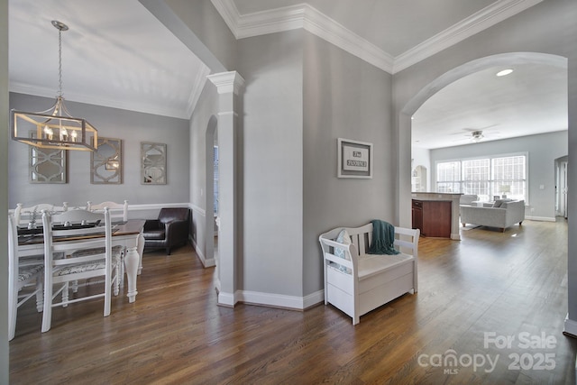 hall with baseboards, arched walkways, dark wood-style flooring, and ornamental molding