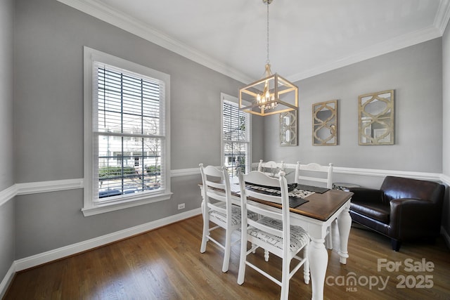 dining area featuring ornamental molding, a notable chandelier, baseboards, and wood finished floors