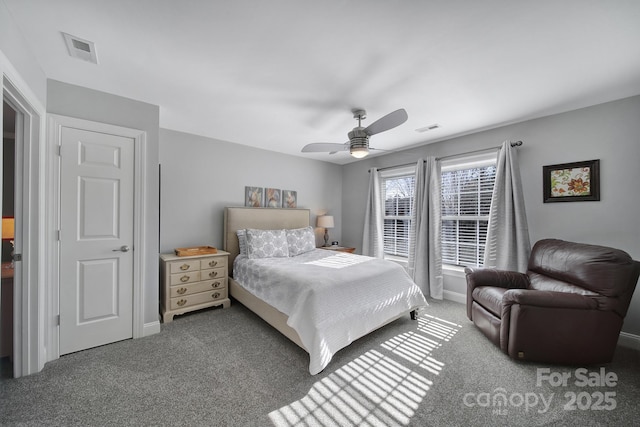 carpeted bedroom featuring a ceiling fan, visible vents, and baseboards