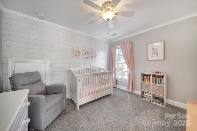 bedroom featuring a ceiling fan, baseboards, a nursery area, carpet, and crown molding