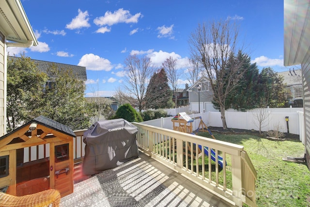 wooden terrace with a lawn, area for grilling, and a fenced backyard