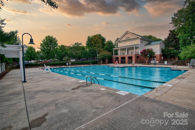 community pool with a patio area and fence