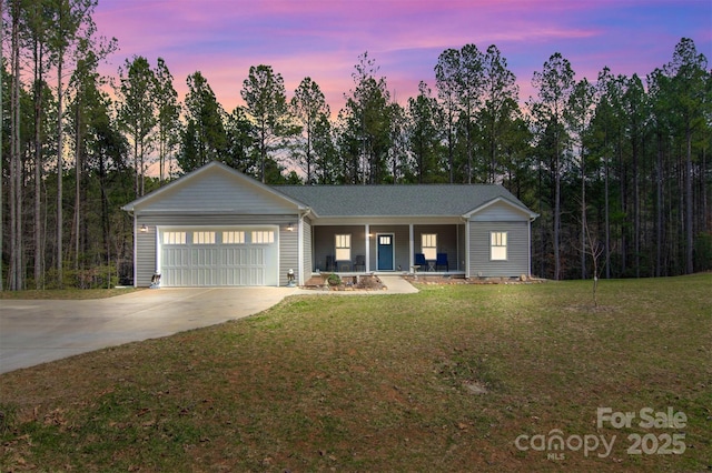 ranch-style home with a garage, driveway, covered porch, and a front yard