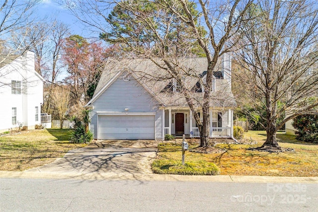 view of front of house with covered porch, concrete driveway, a front yard, and a garage