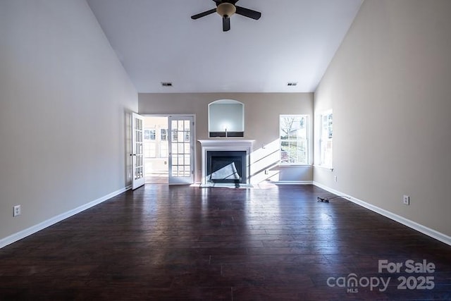 unfurnished living room featuring plenty of natural light, a fireplace, and wood finished floors