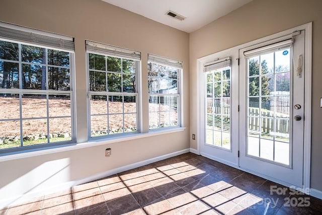 doorway to outside with baseboards, visible vents, and stone finish flooring